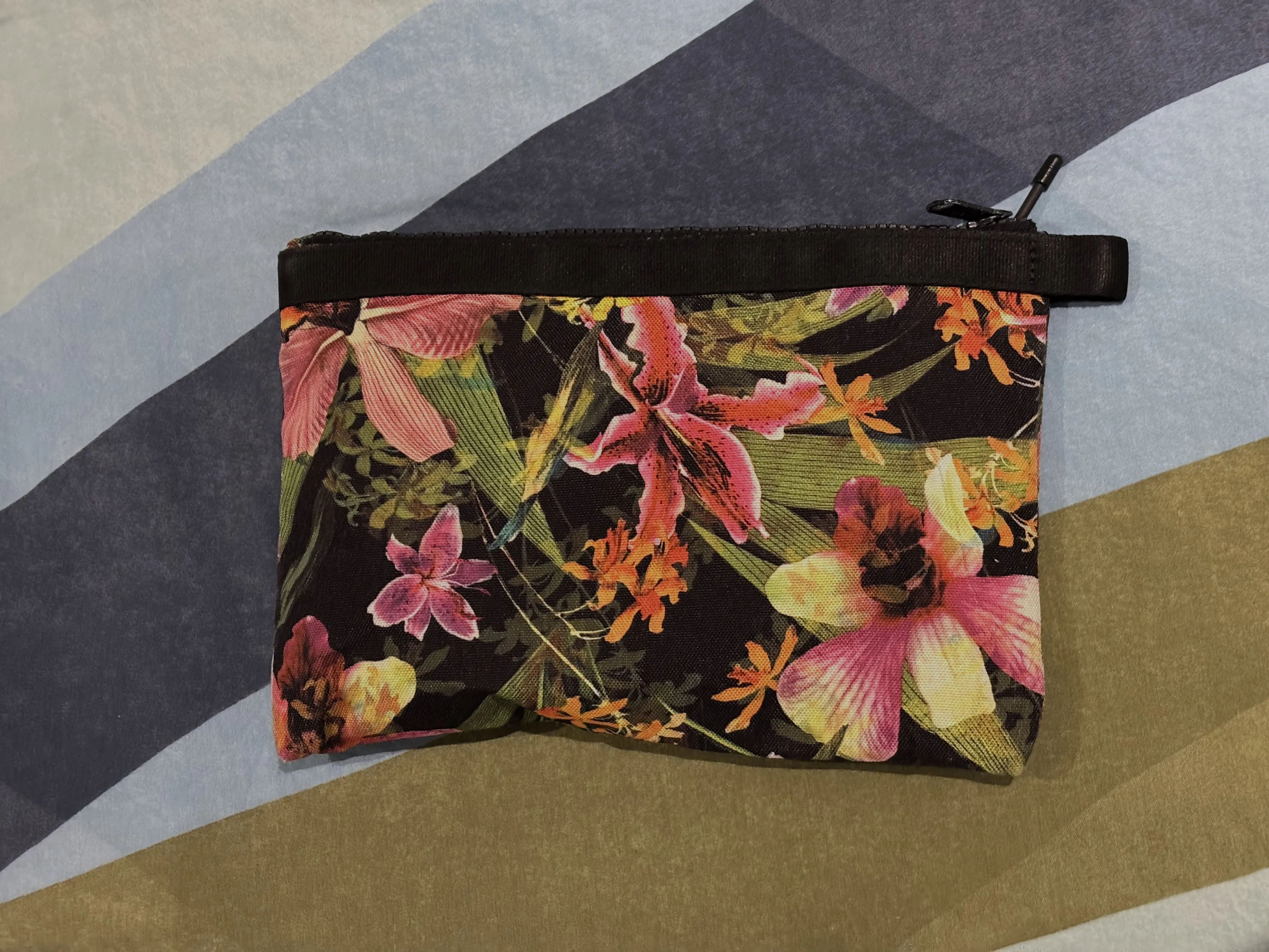 Photo of the outside of the zippered pouch. The tip of an antenna is sticking out from where the zipper pull meets the end of the zipper track