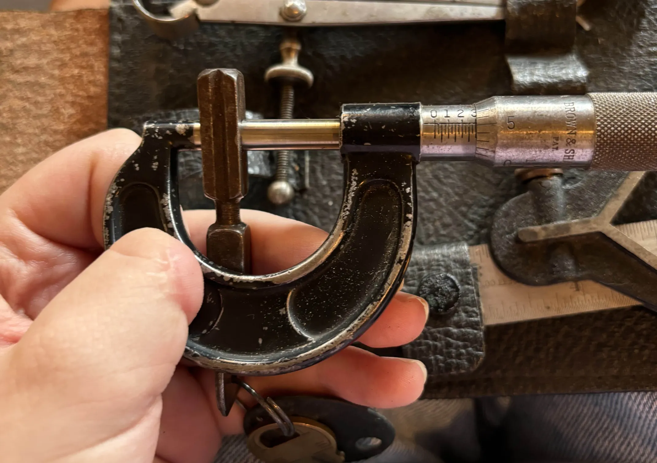 Antique micrometer measuring the cab key to be 0.305 inches or 7.76 mm